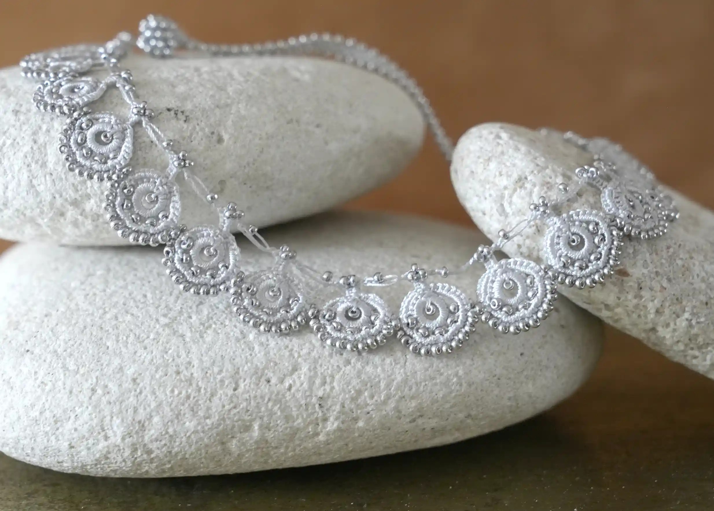 Zoom sur le collier en dentelle Eda gris argent fait main, de la marque Karawan