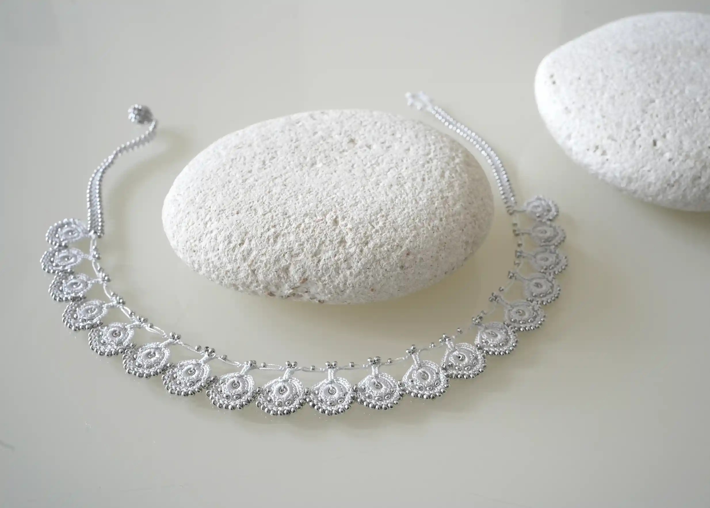 Le collier en dentelle Eda gris argent avec des motifs ornés de perles argentées
