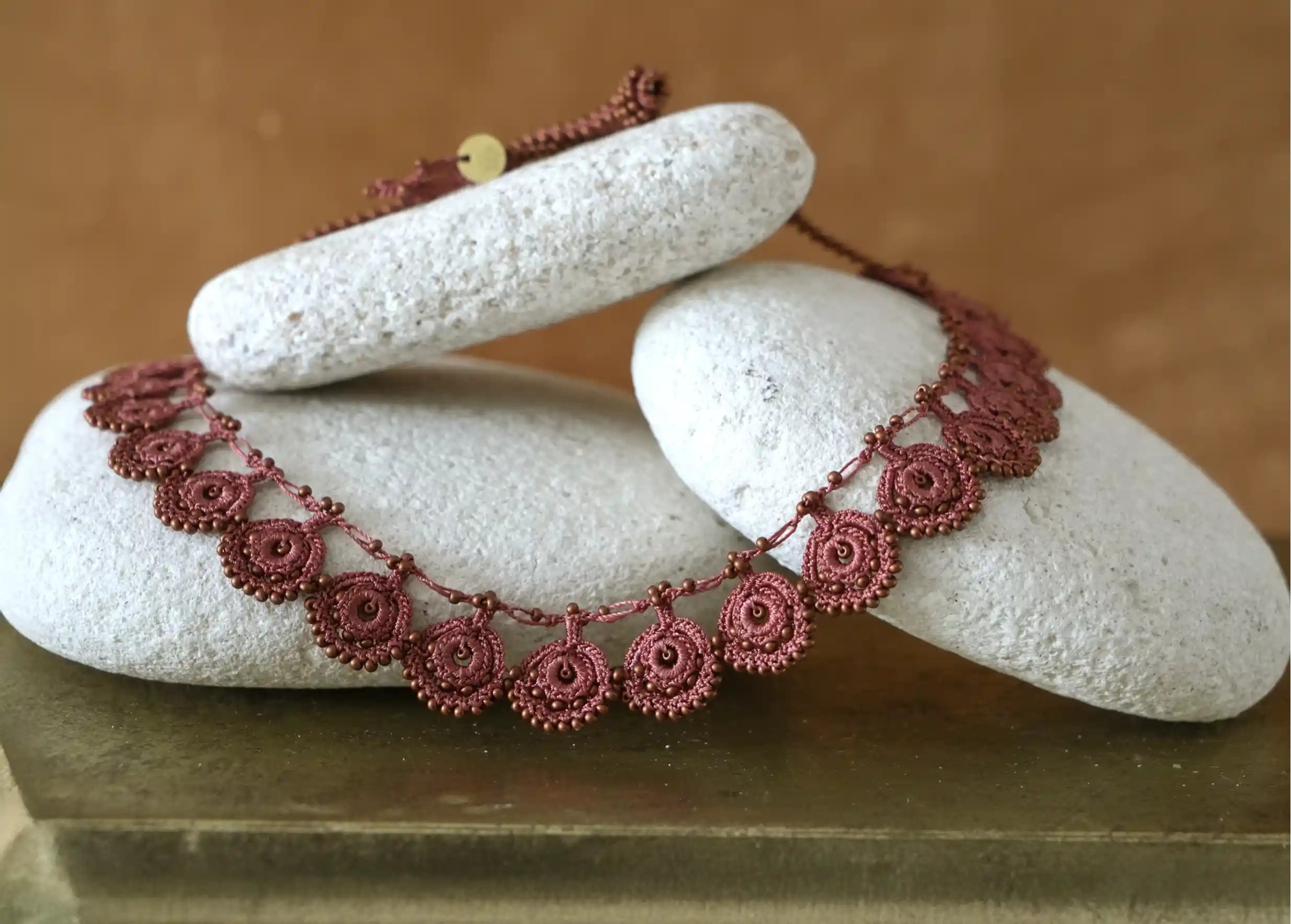 Focus on the handmade Eda matte copper lace necklace from Karawan