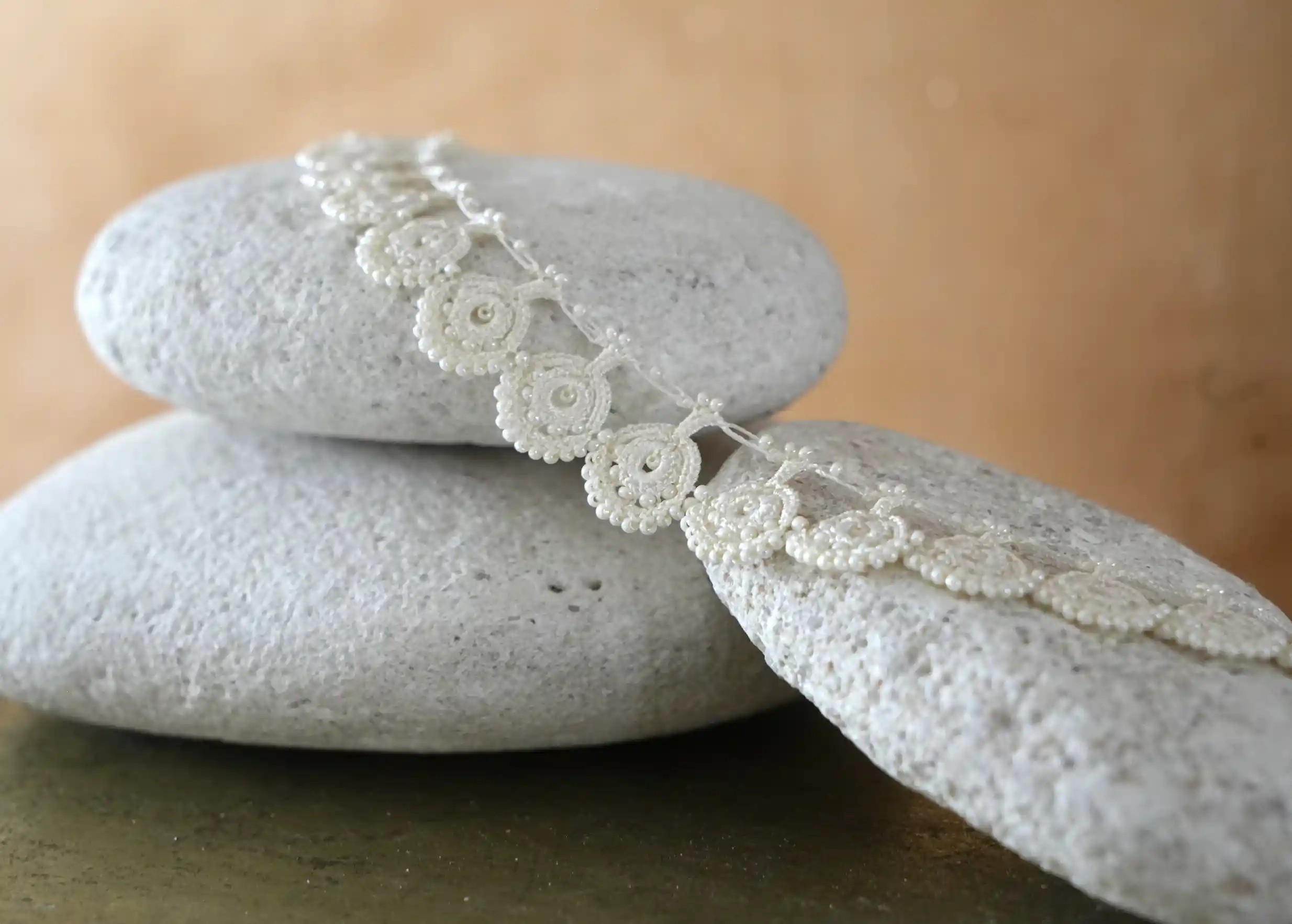 Close-up of the pattern on Karawan's ivory-colored Eda lace necklace