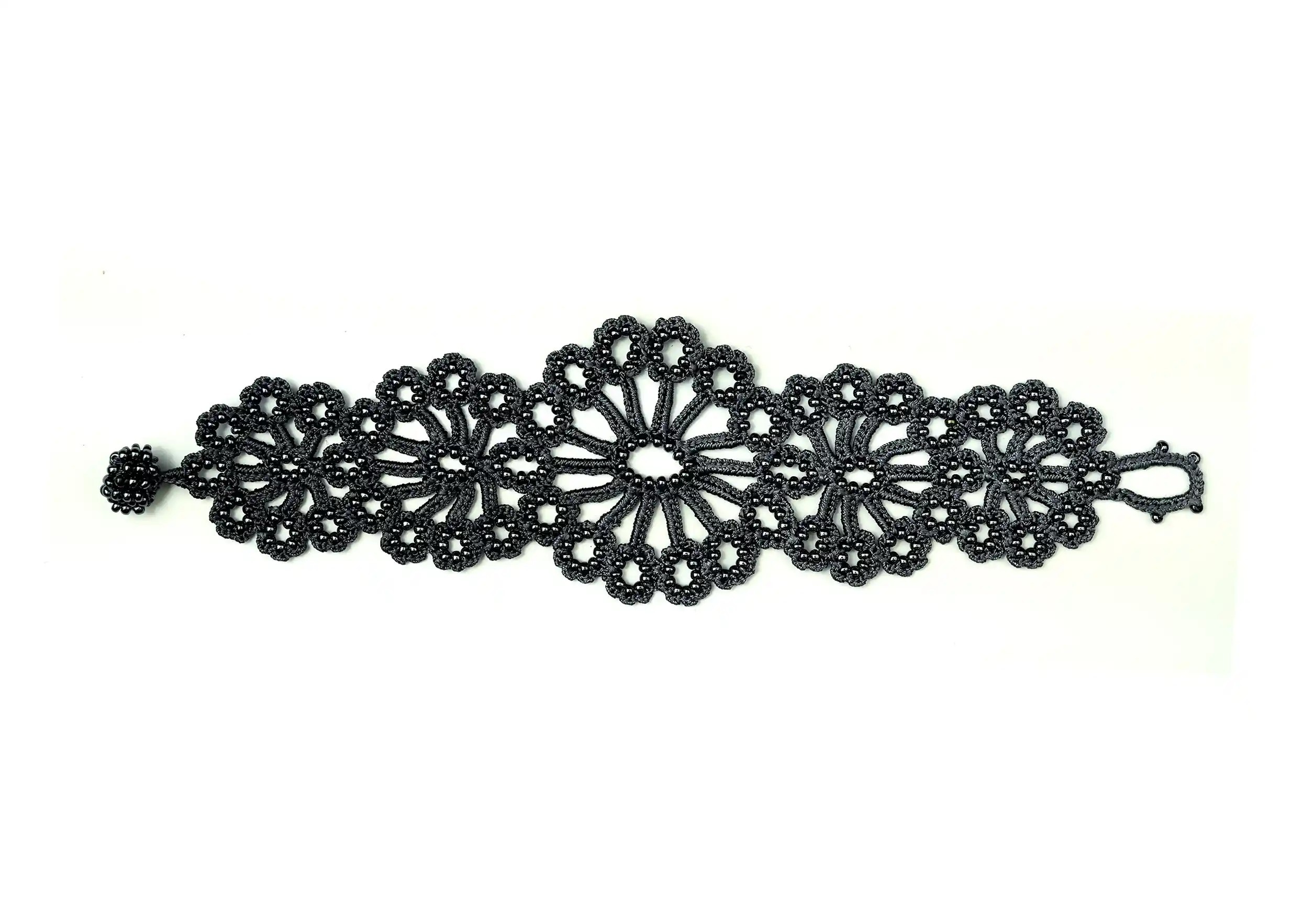 Hawa lace bracelet in slate blue, decorated with pearls, white cut-out background