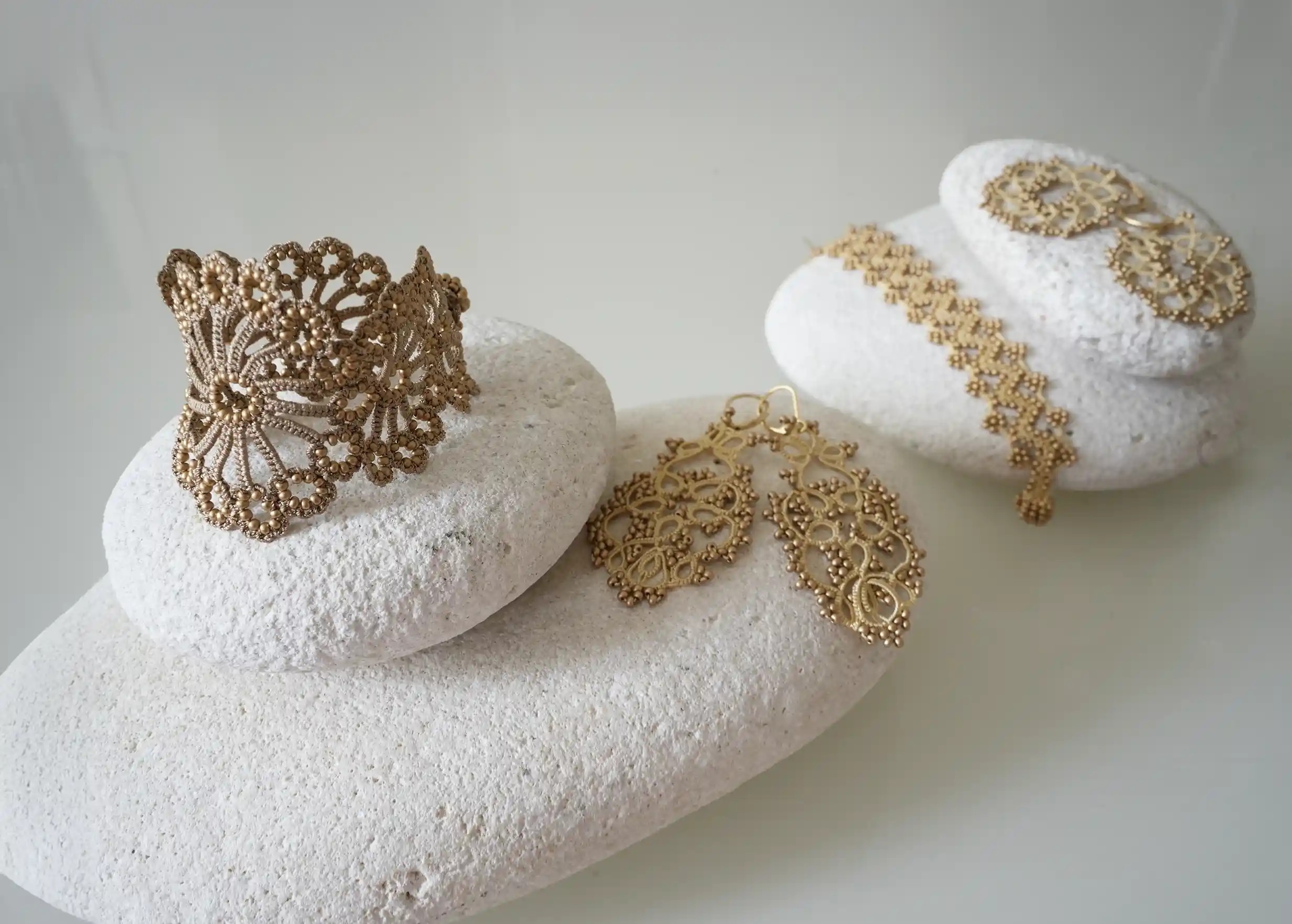 Set of several Oya jewellery designs by Karawan, in golden tones on white backgrounds.