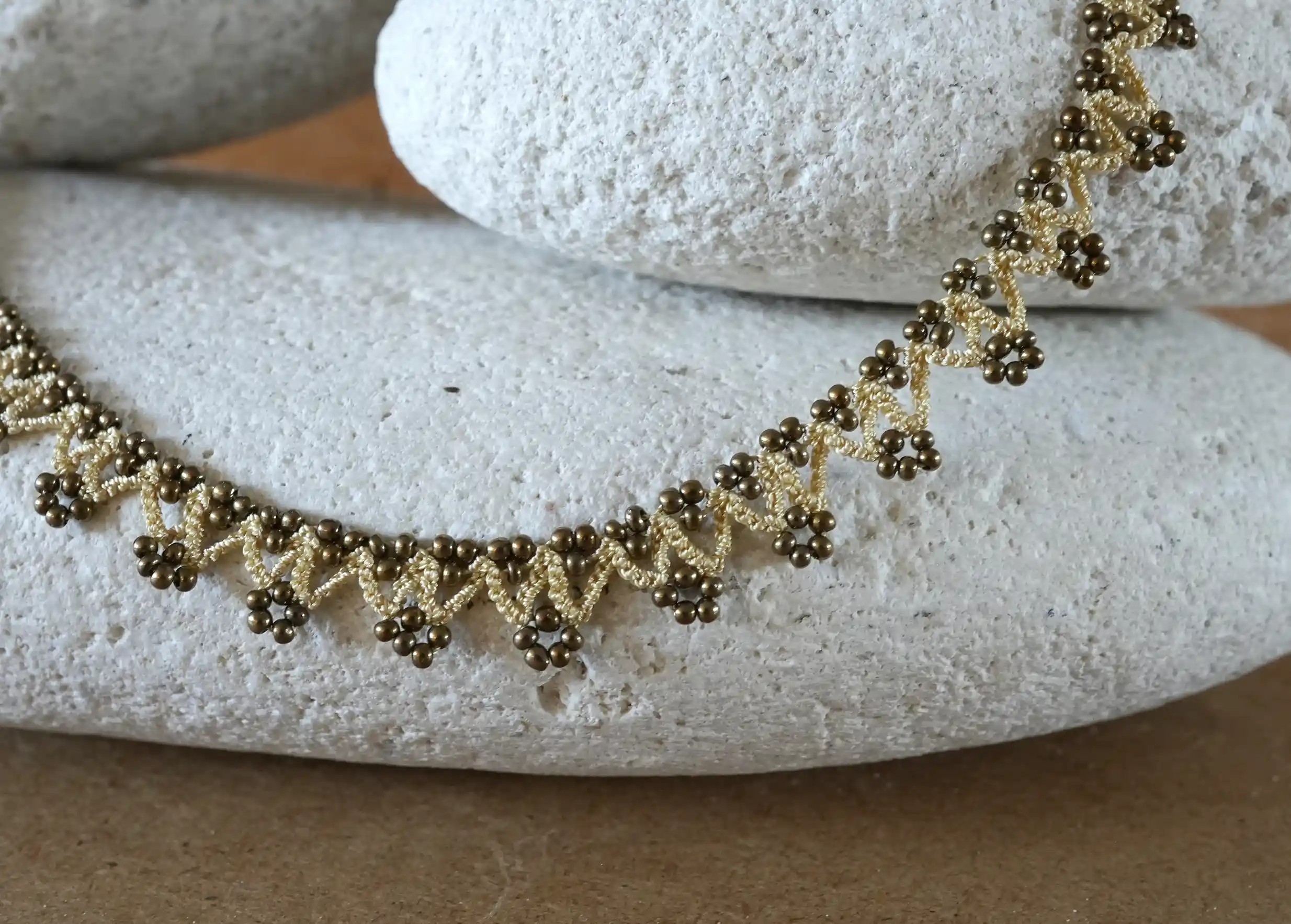 Zoom sur les détails du collier 'Liana' coloris beige, or et cuivre de la marque Karawan authentic