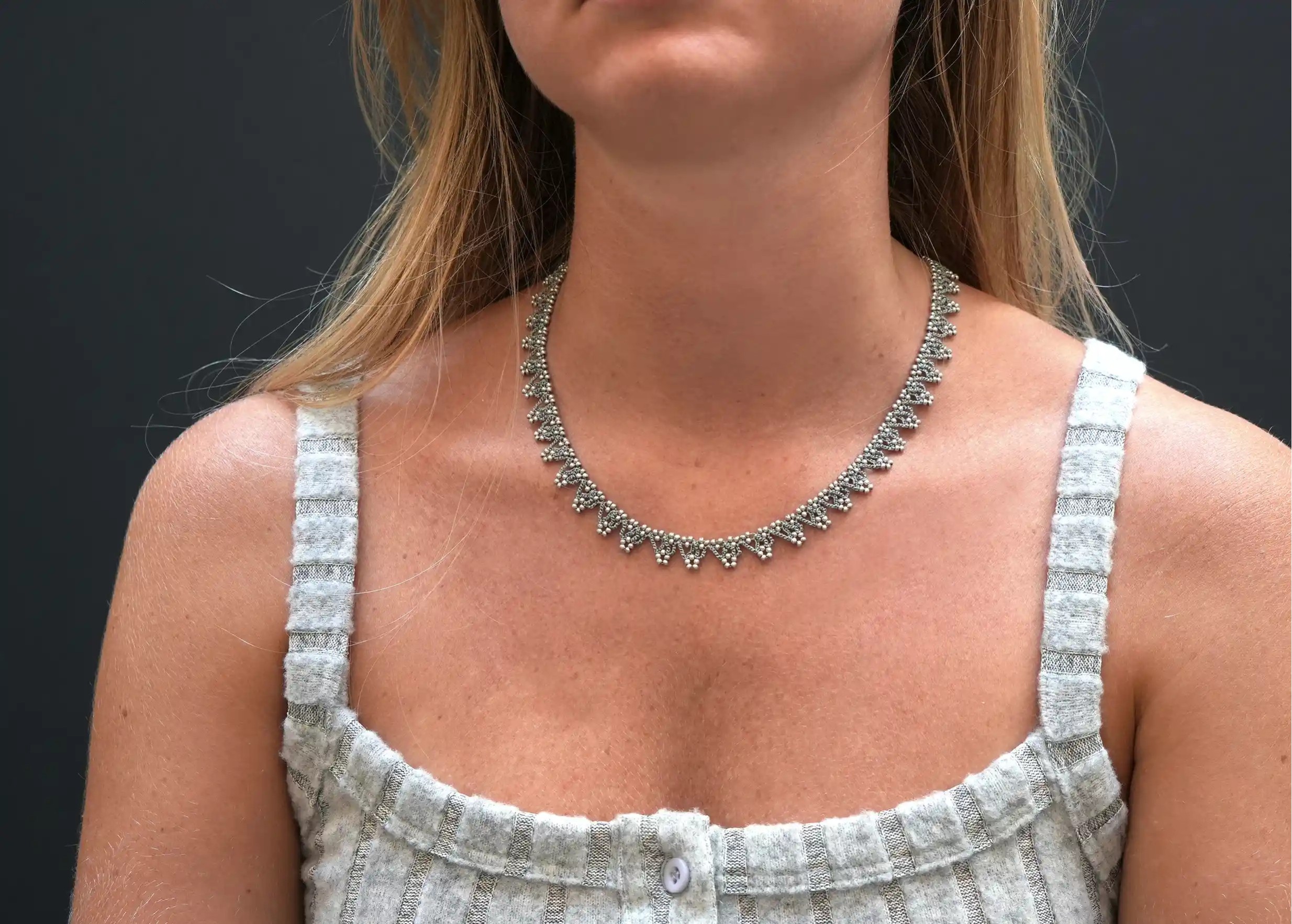 Jeune femme portant au cou un collier 'Liana' coloris bleu acier et argent