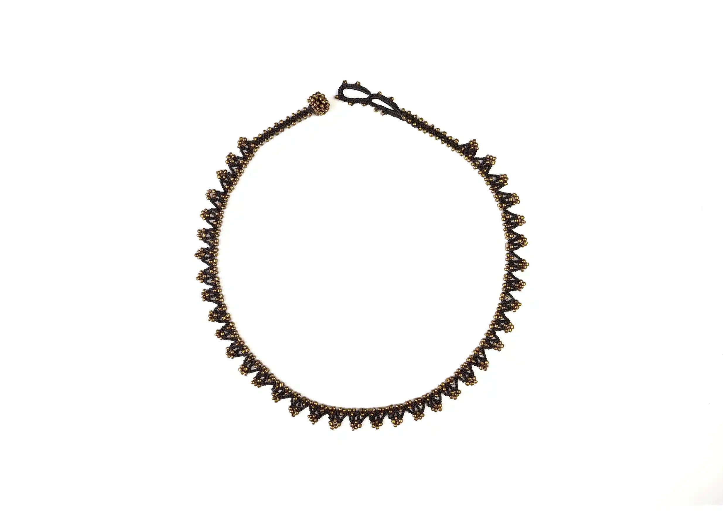 'Liana' necklace in black and bronze, photo taken against a white background