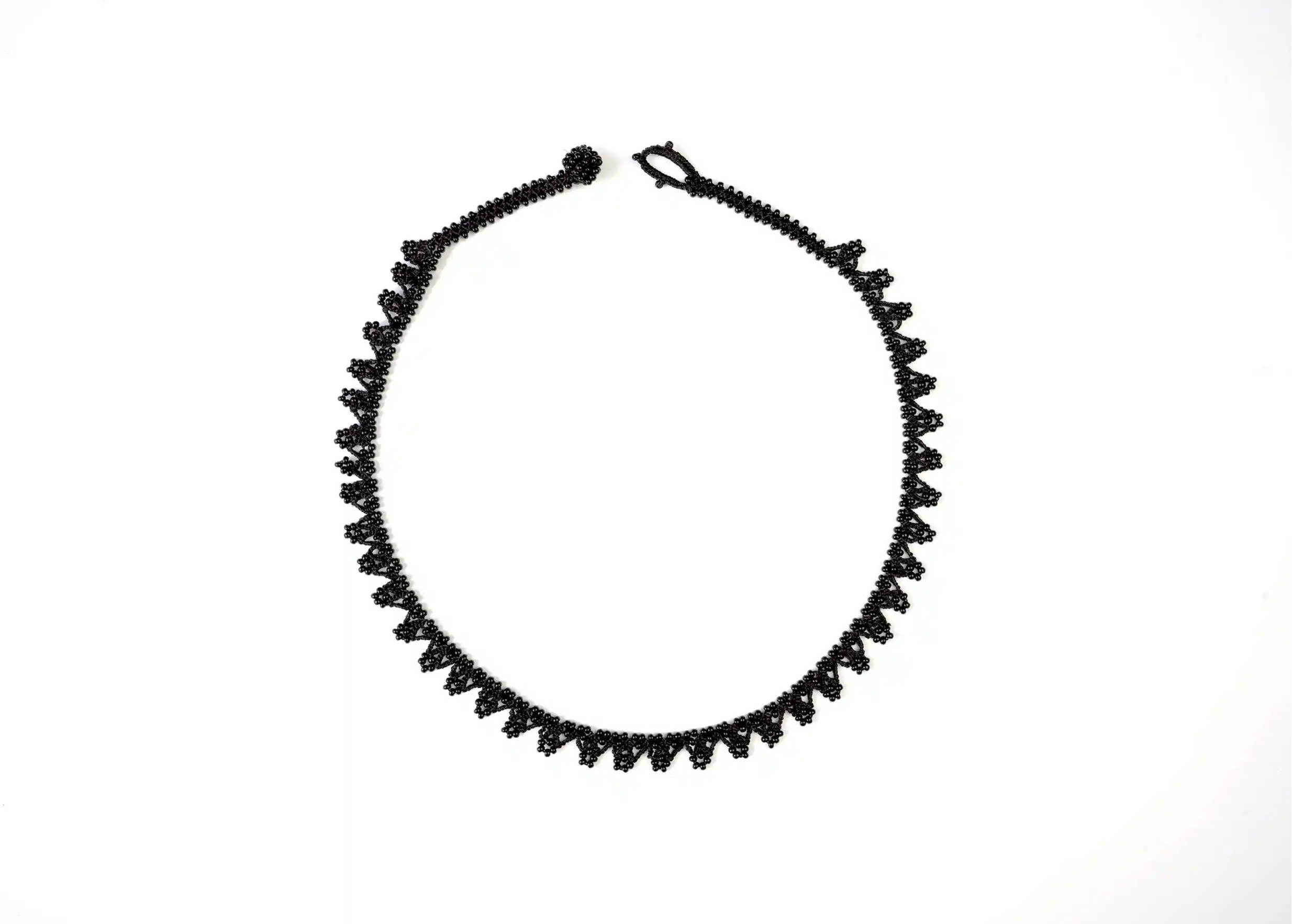 All-black textile necklace from the Karawan Authentic brand, photo taken against a white background