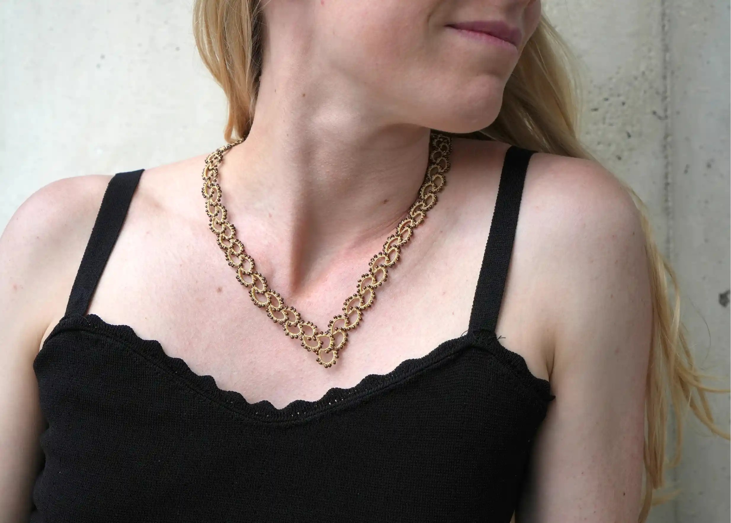 Woman wearing a handmade lace and pearl necklace, Seed model in beige and gold