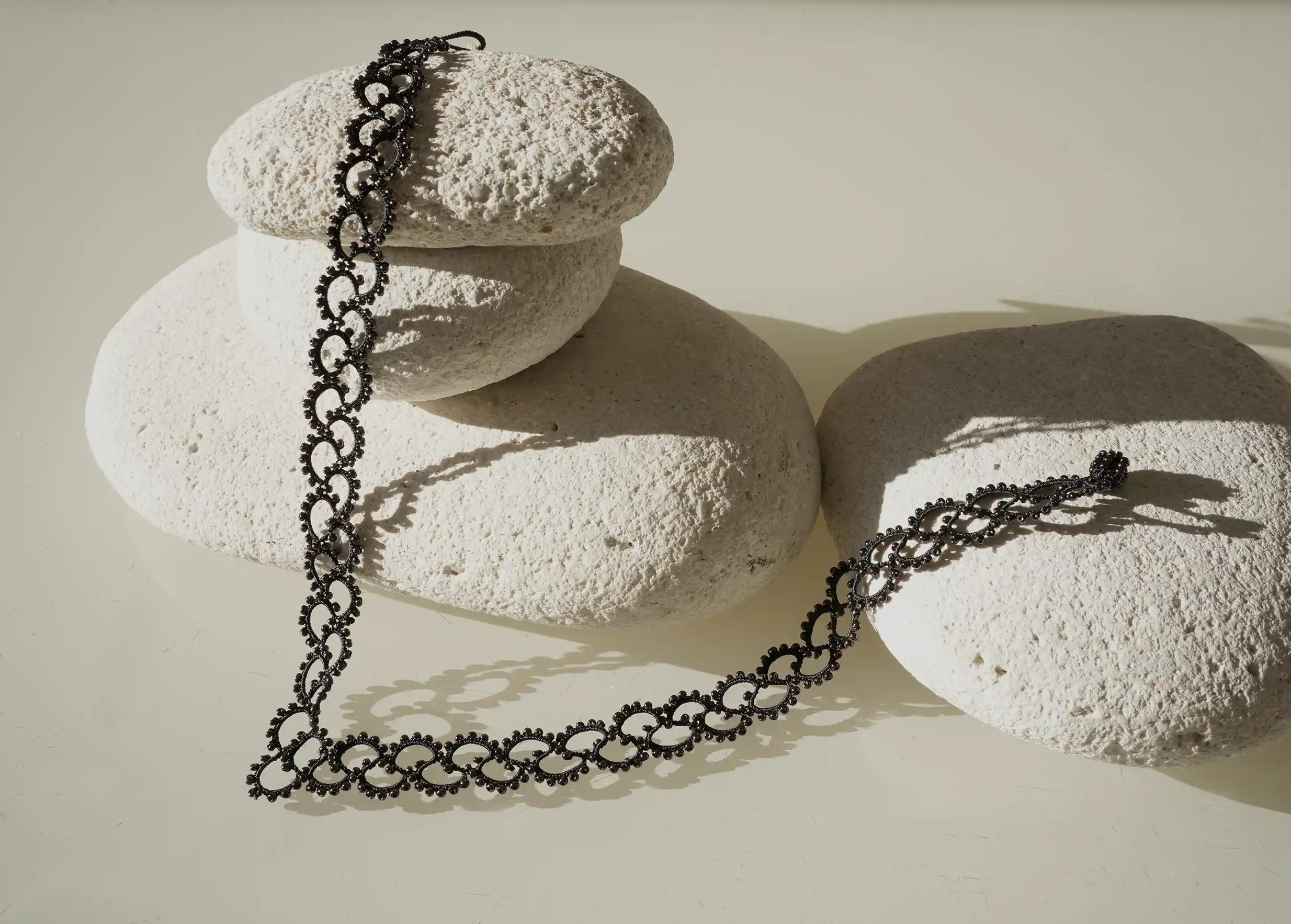 Détails du collier en dentelle et perles réalisé à la main, modèle Seed et coloris noir