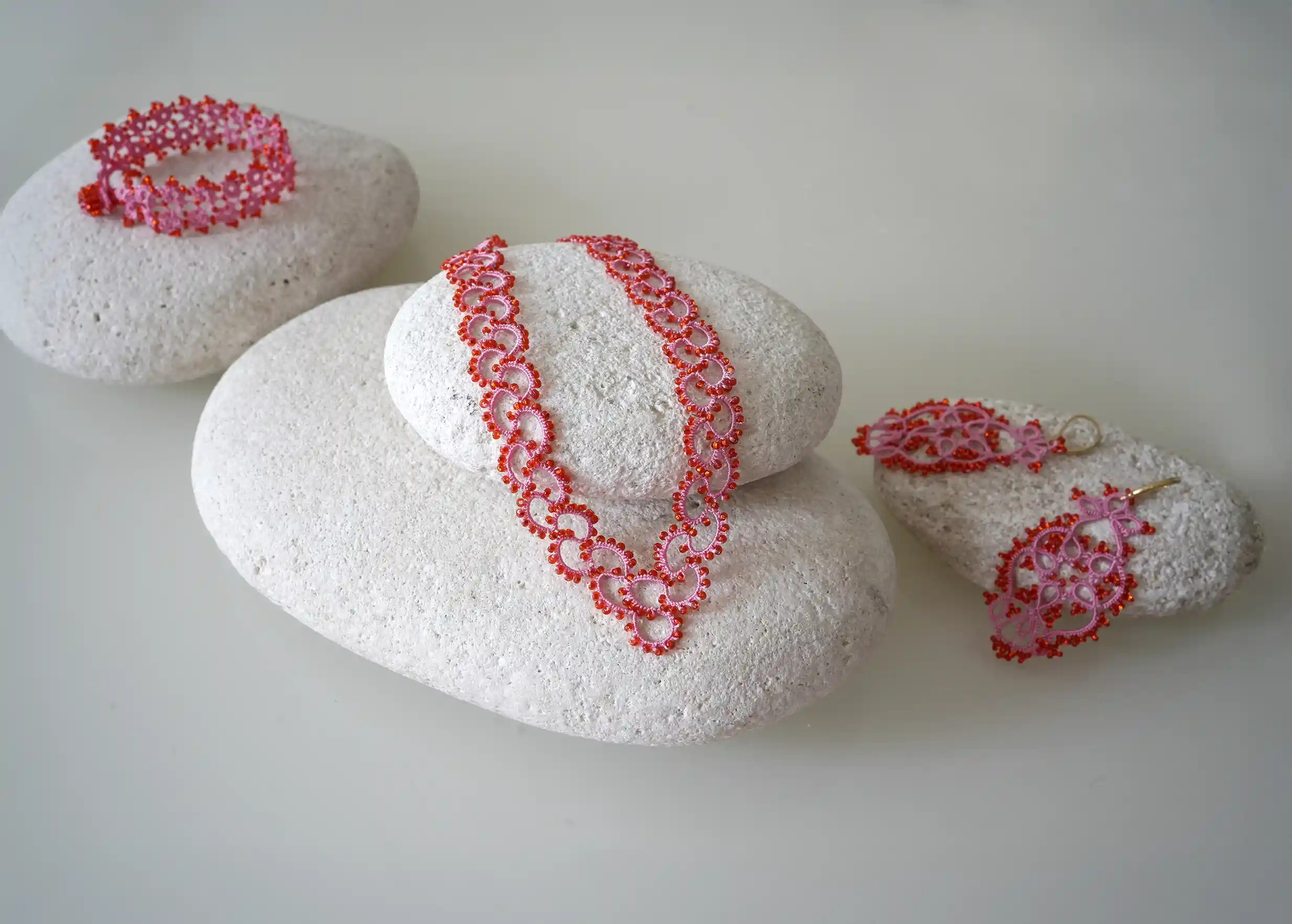 Ensemble de la gamme en dentelle et perles réalisé à la main, modèle Seed et coloris rose et rouge