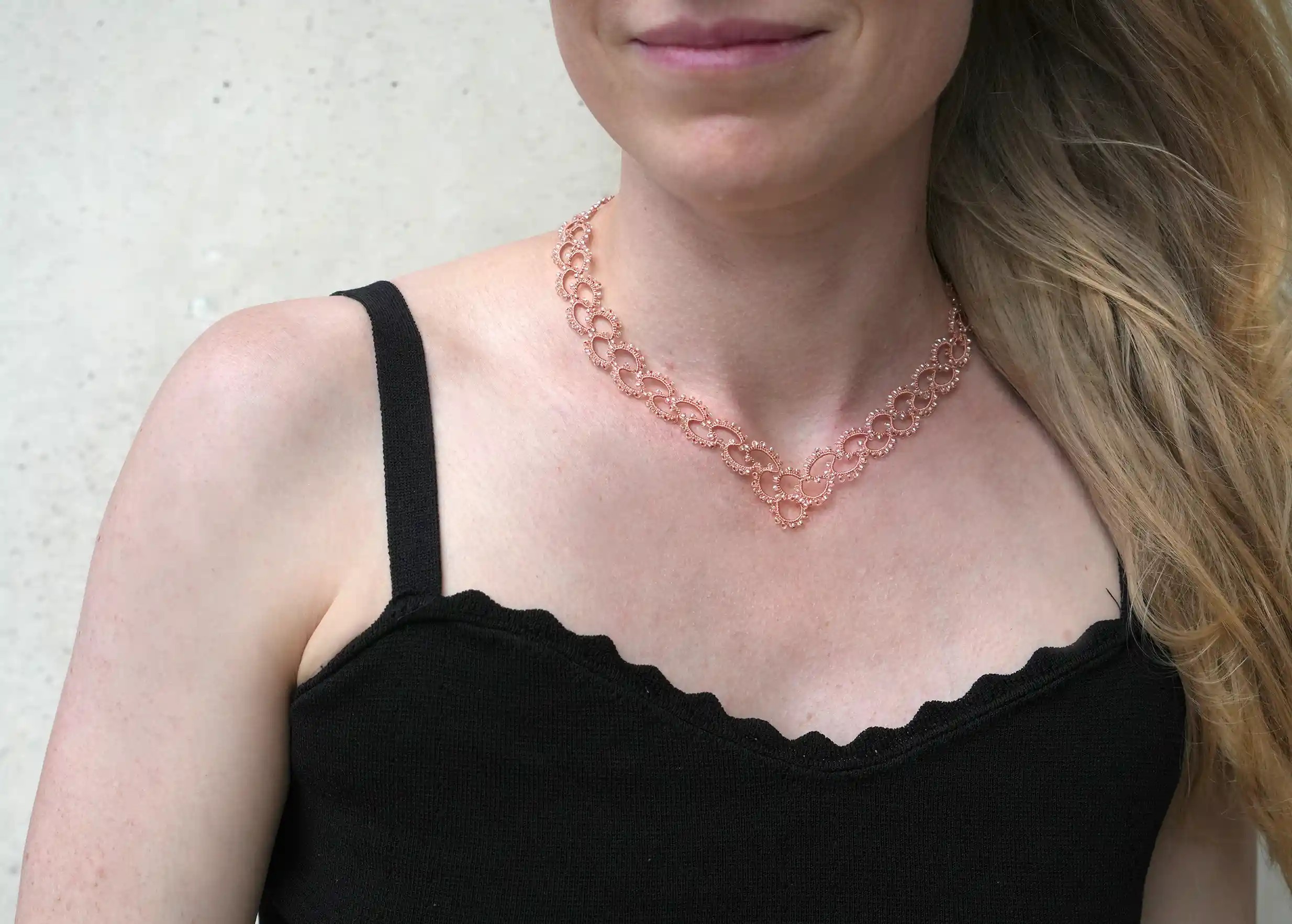 Femme portant un collier en dentelle et perles réalisé à la main, modèle Seed et coloris Terracotta et transparent