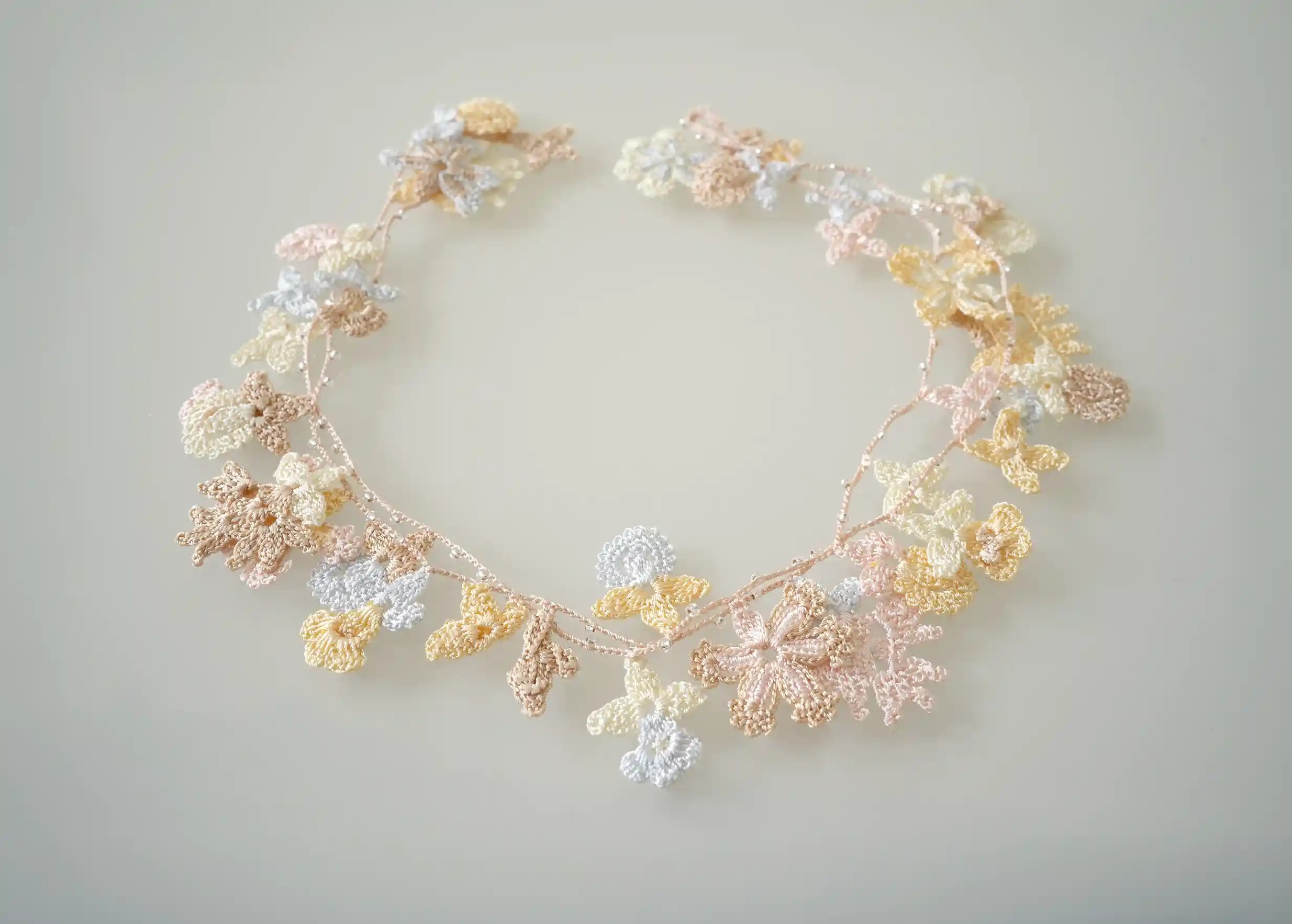 Sautoir en dentelle aux motifs végétaux de fleurs et de feuilles, Bloom coloris nacre de la marque Karawan