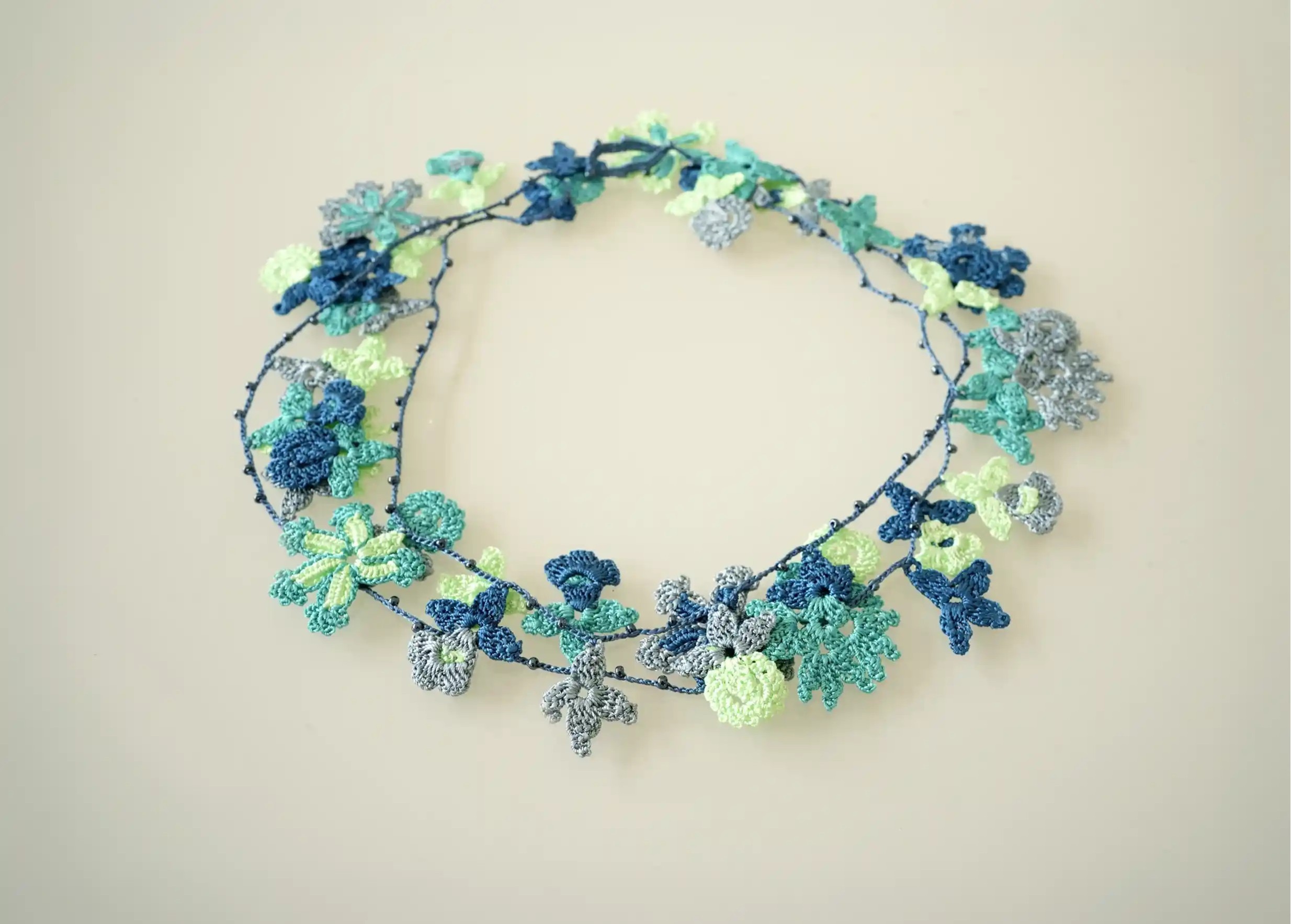 Sautoir en dentelle aux motifs végétaux de fleurs et de feuilles, Bloom coloris océan de la marque Karawan