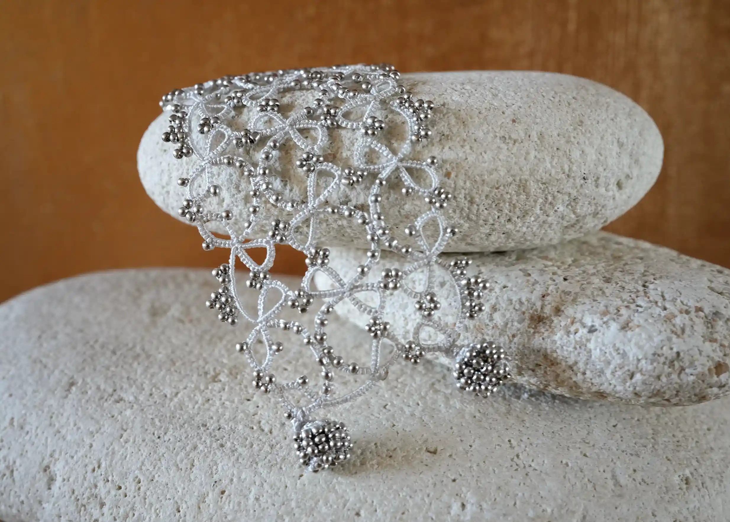 Focus on the details of the wide lace cuff bracelet, Crown model, silver grey colour