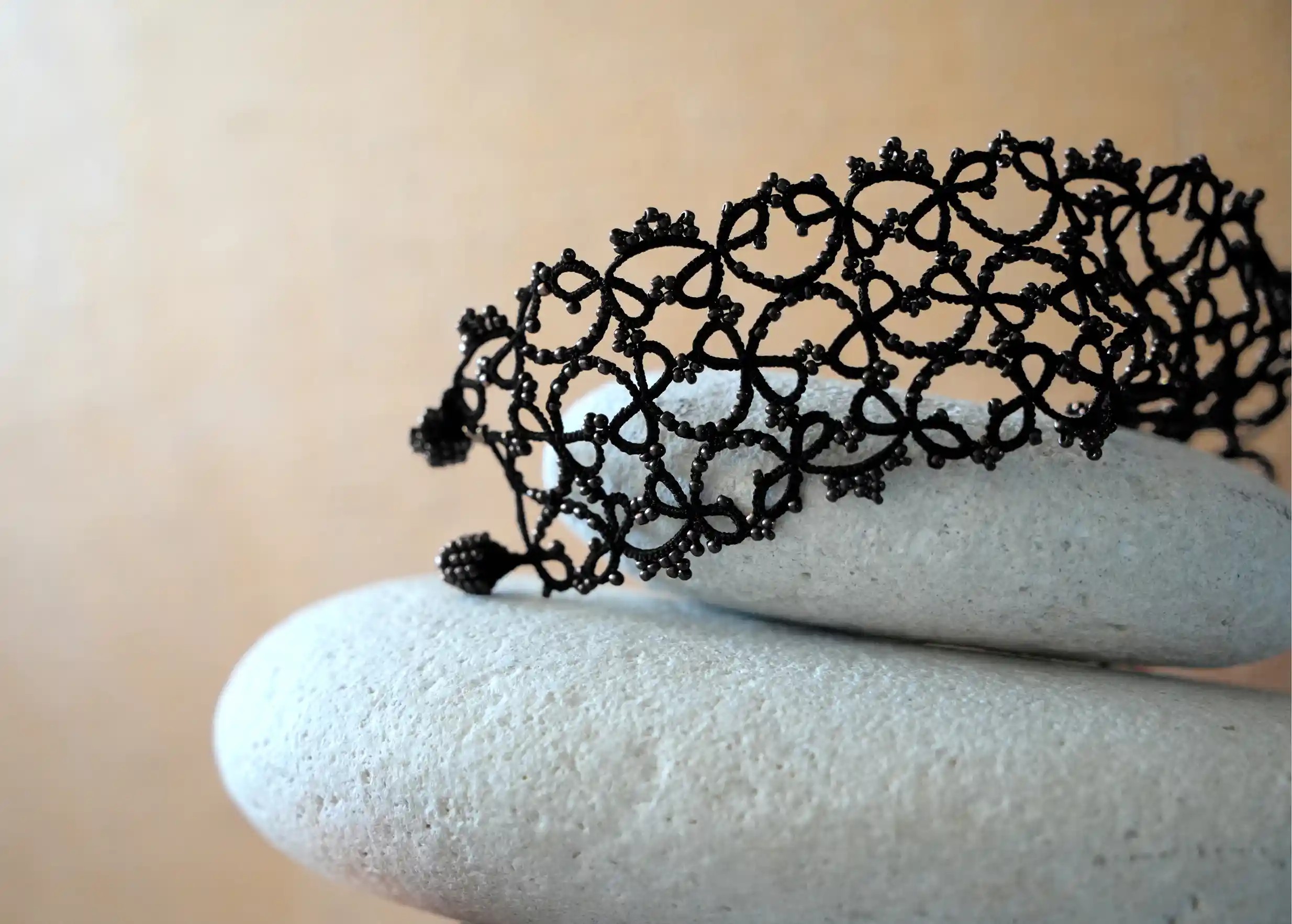 Zoom sur les détails du bracelet manchette large en dentelle, modèle Crown et modèle noir