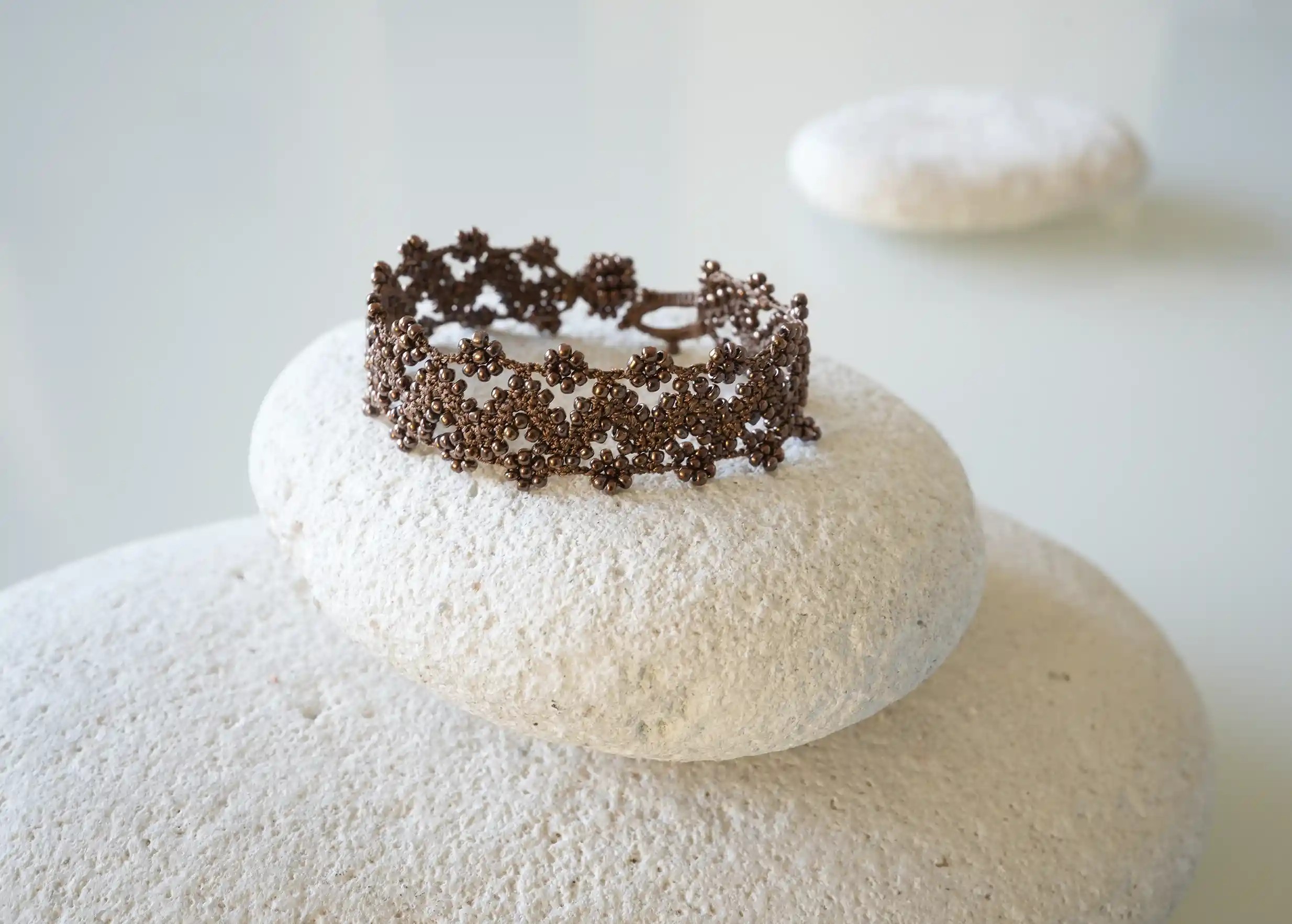 Textile bracelet made of thread and beads, with graphic patterns, Ribbon model in amber brown colour