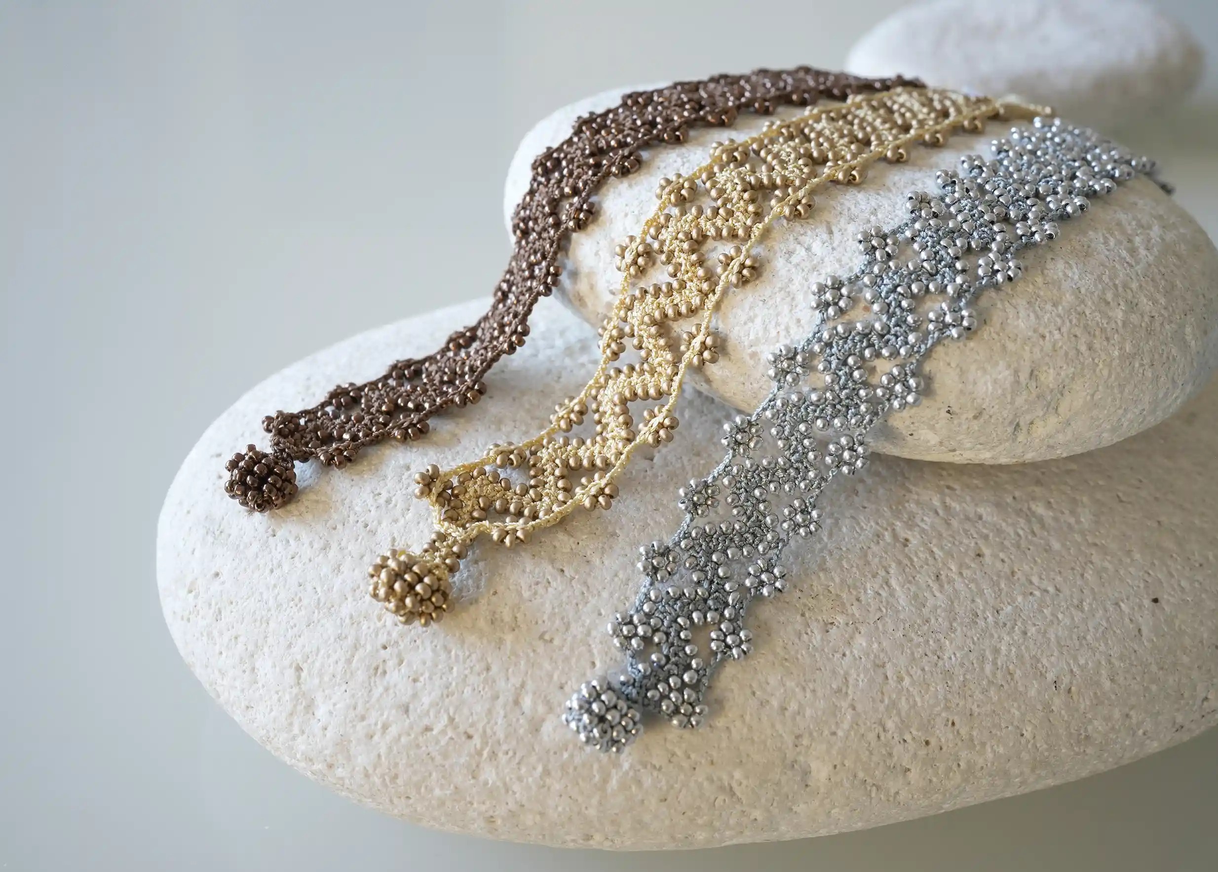 Zoom sur un ensemble de bracelet textile en fil et perles, avec des motifs graphiques, modèle Ribbon