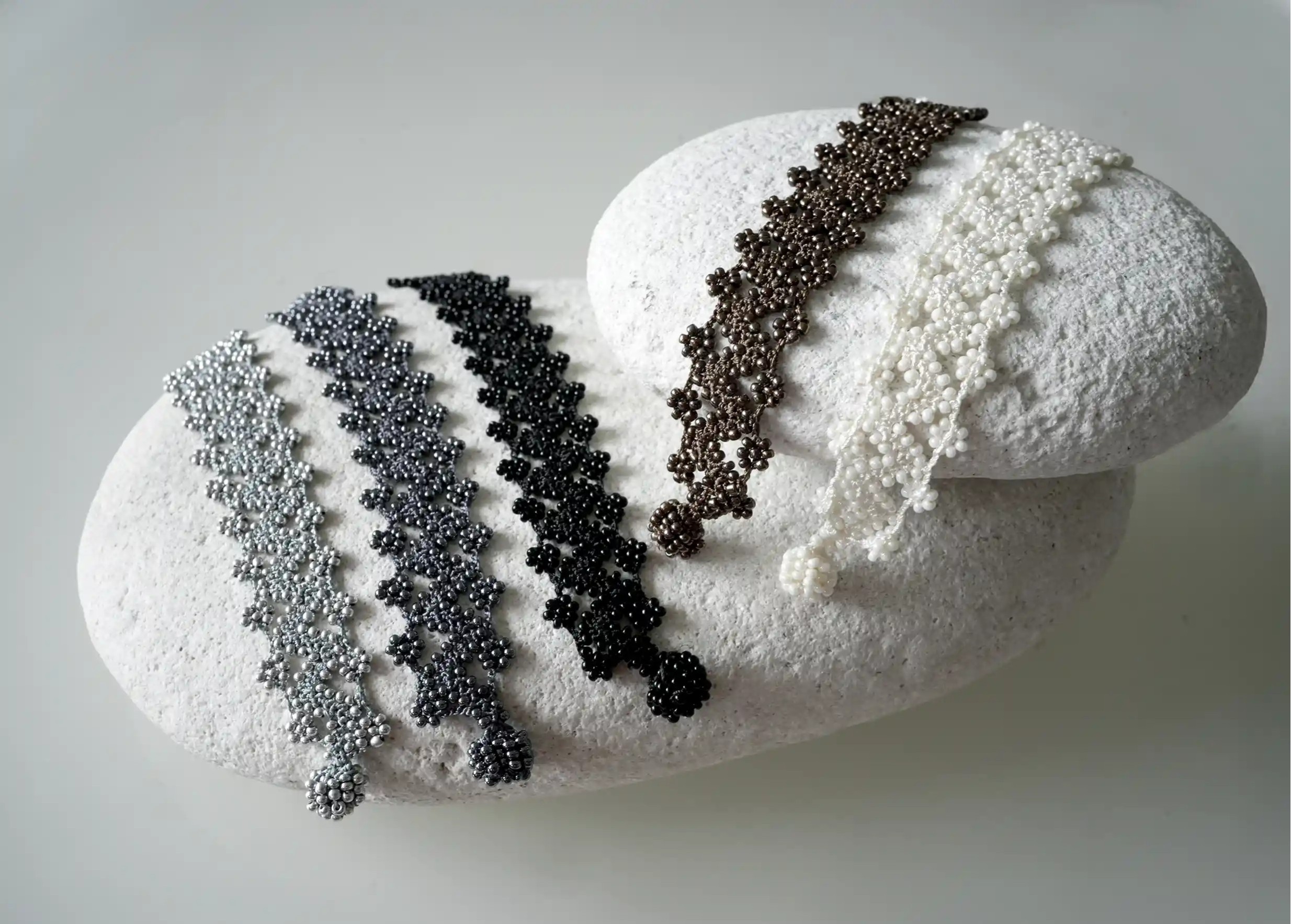Complete range of textile bracelets made from thread and beads, with graphic designs, Ribbon model