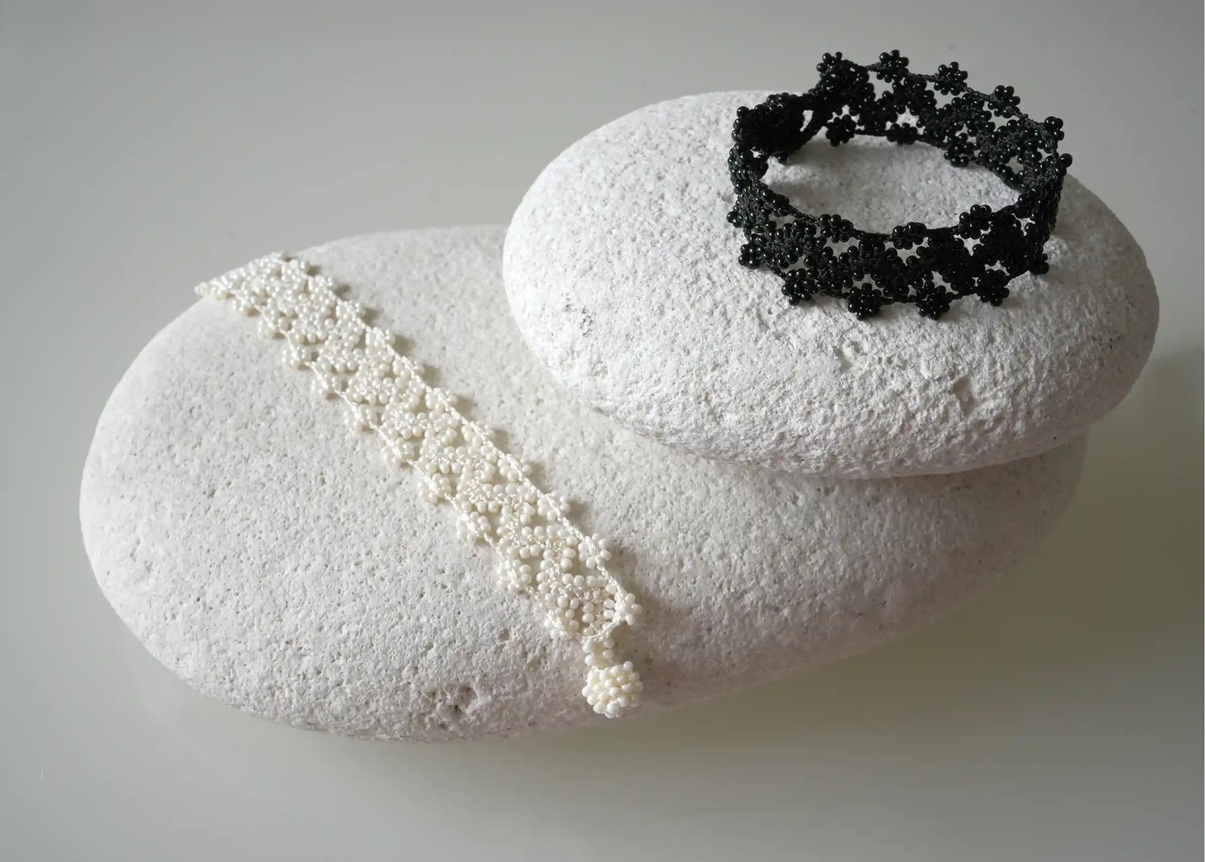 Duo de bracelets textile  ivoire clair et noir en fil et perles, avec des motifs graphiques, modèle Ribbon
