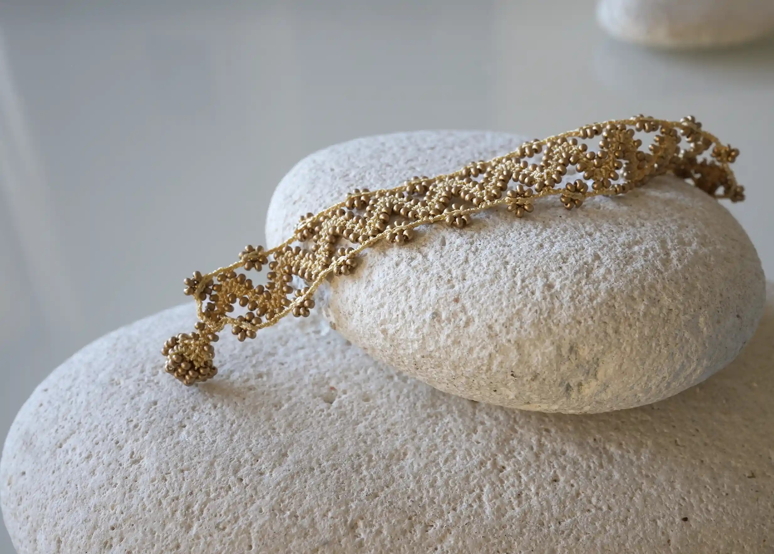 Bracelet textile en fil et perles, avec des motifs graphiques, modèle Ribbon coloris or mat