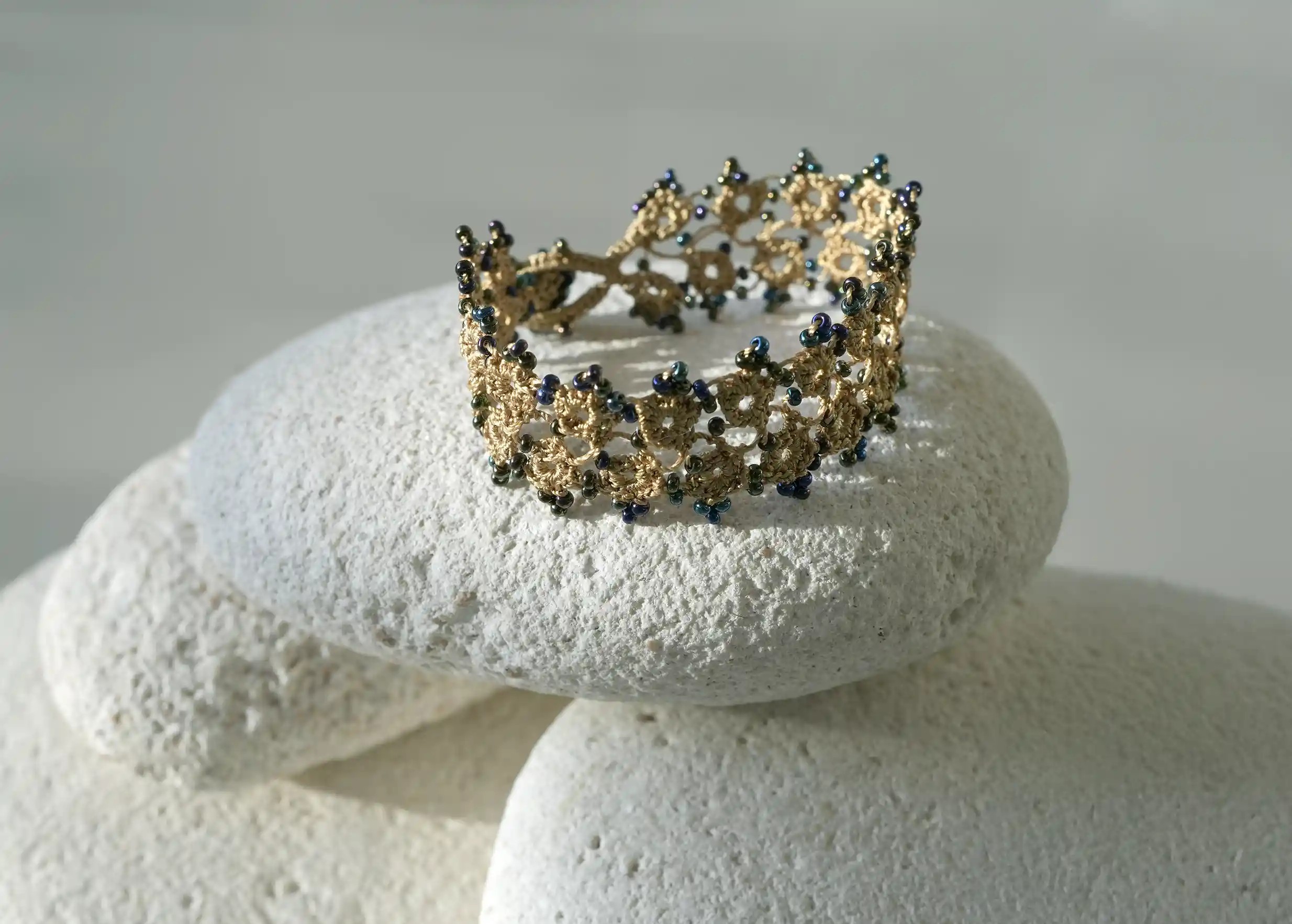 Handmade lace textile bracelet, Husnu, OYA collection, lichen green colour on a pebble