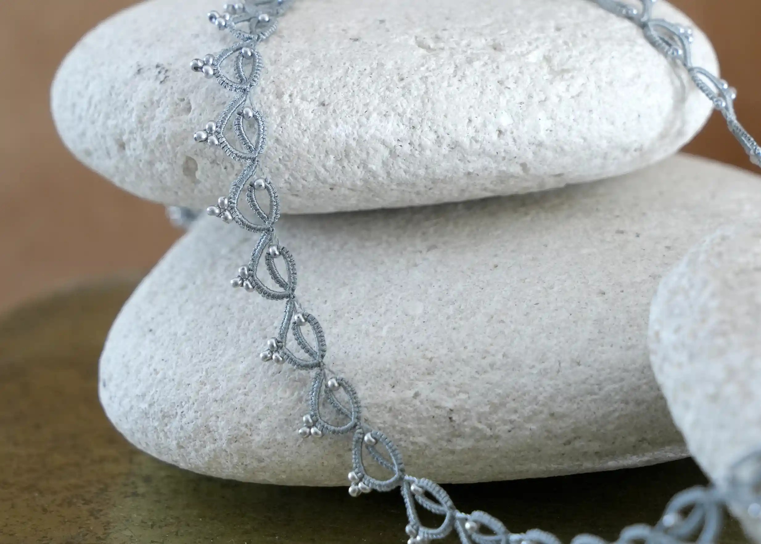 Focus on the handmade choker necklace made of thread and beads, Lotus Chain in glacier blue and silver