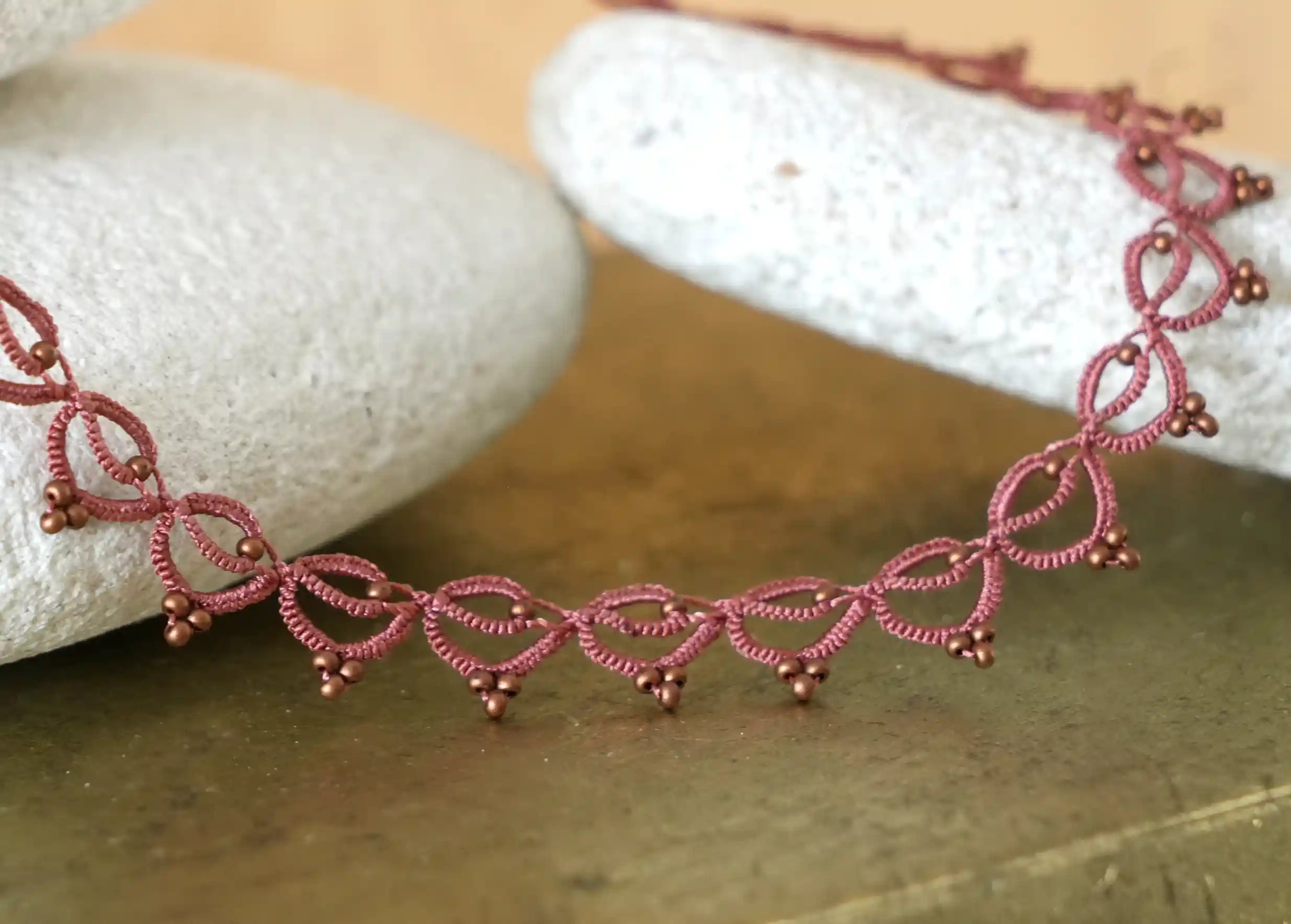 Collier tour de cou fait main en fil et perles près d'un galet, Lotus Chain coloris cuivre mat