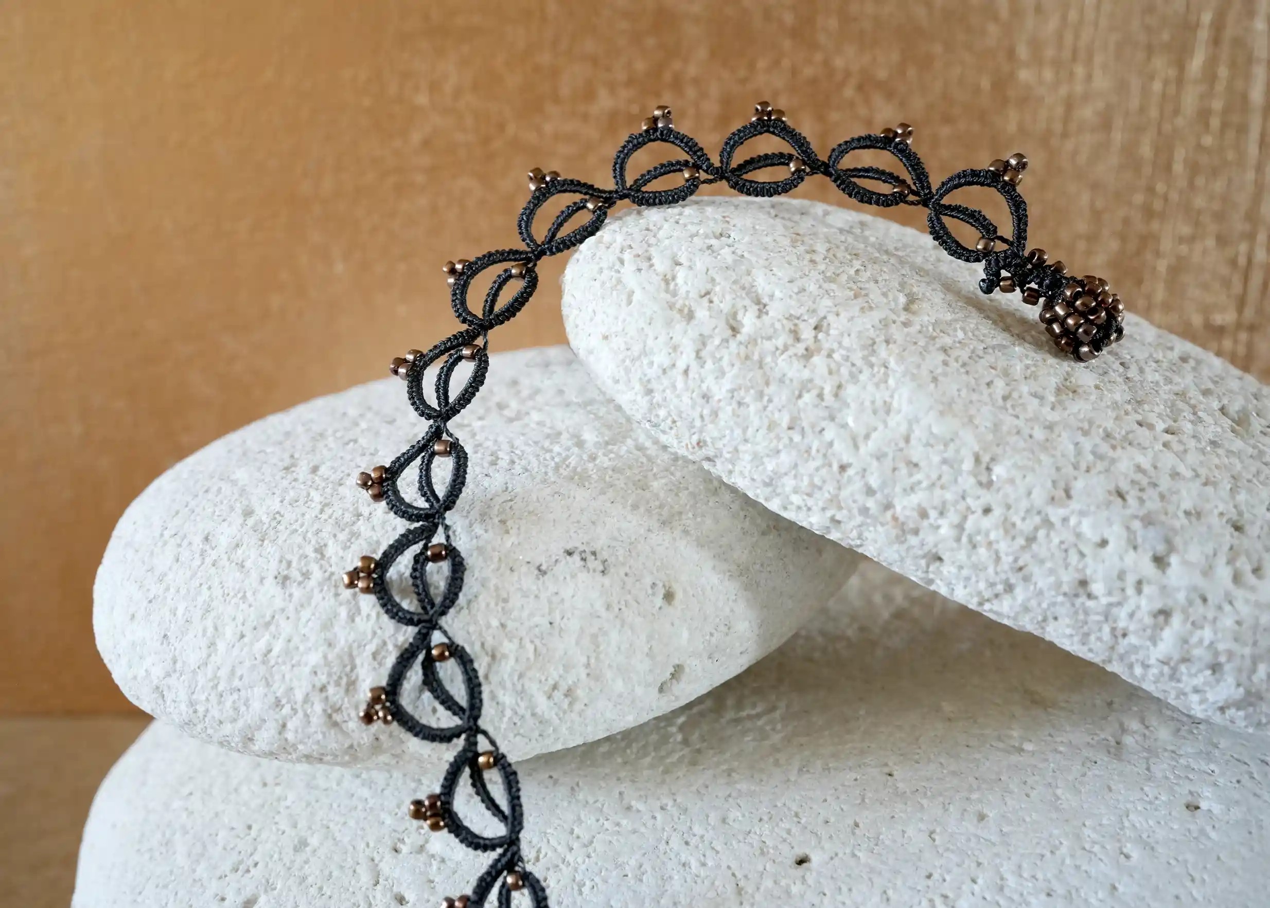 Collier tour de cou fait main en fil et perles près d'un galet, Lotus Chain coloris noir