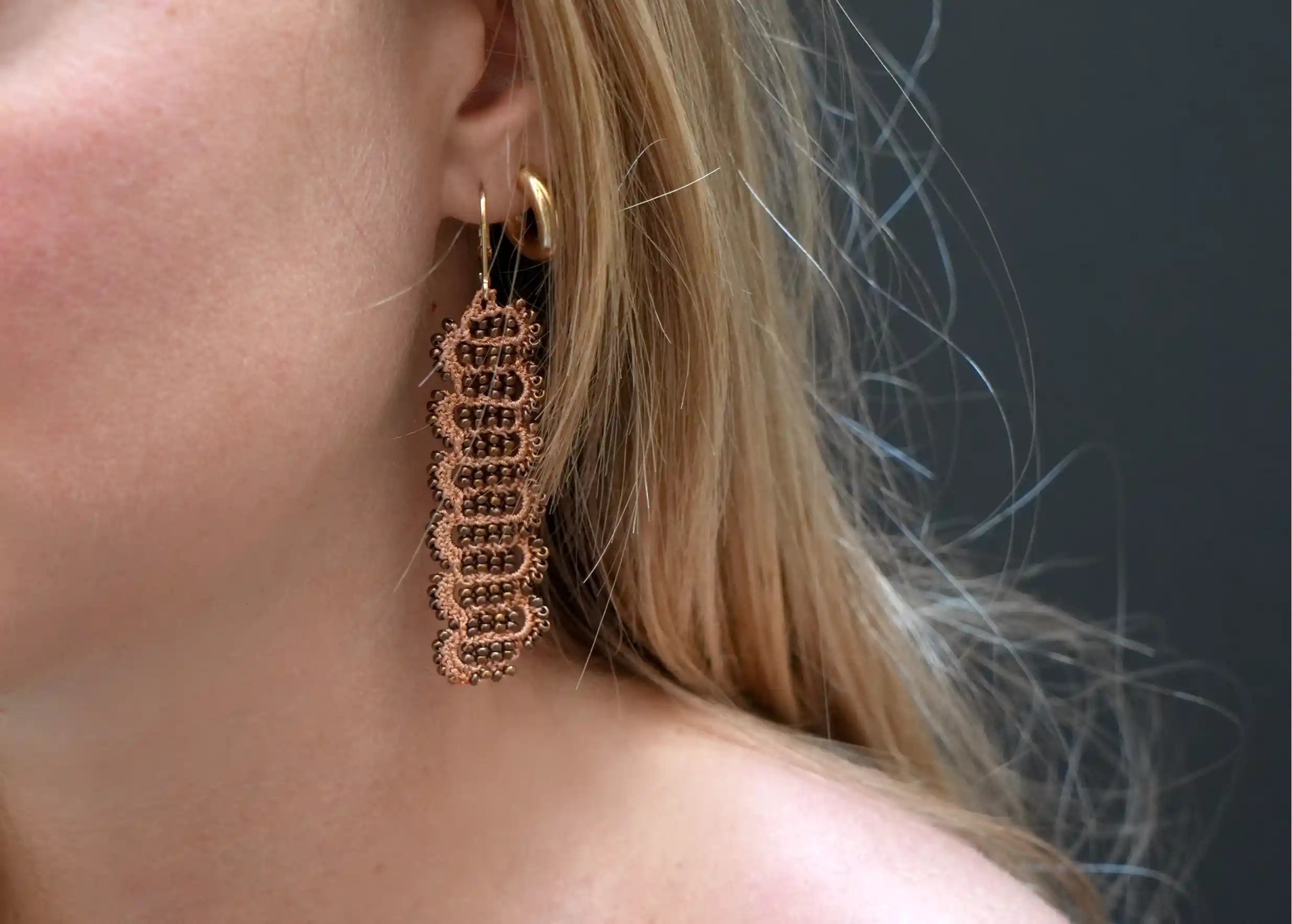 Woman wearing Karawan earrings, Bark model, Terracotta and copper colours