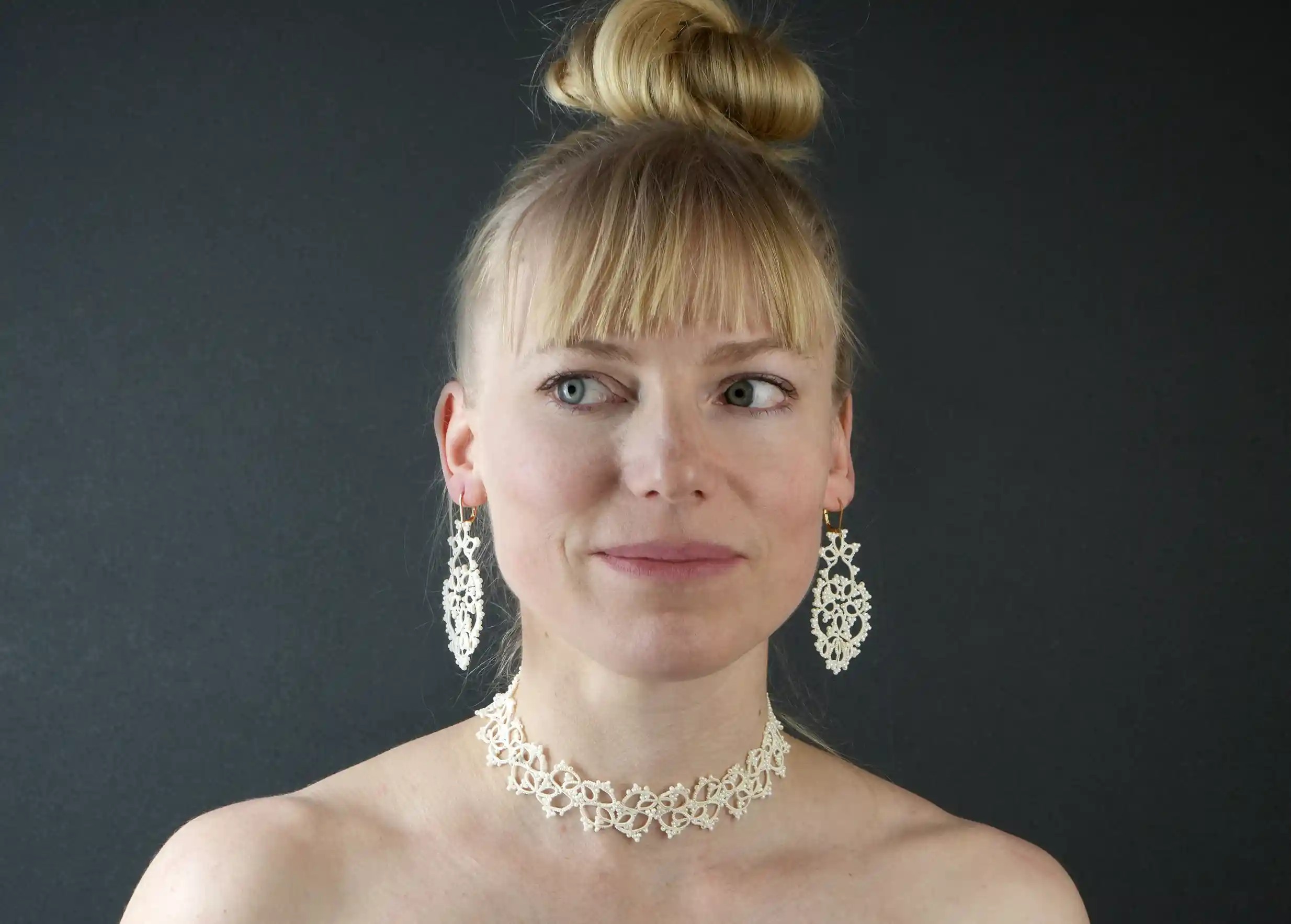 Woman wearing handmade lace jewellery, TREE model, light ivory colour