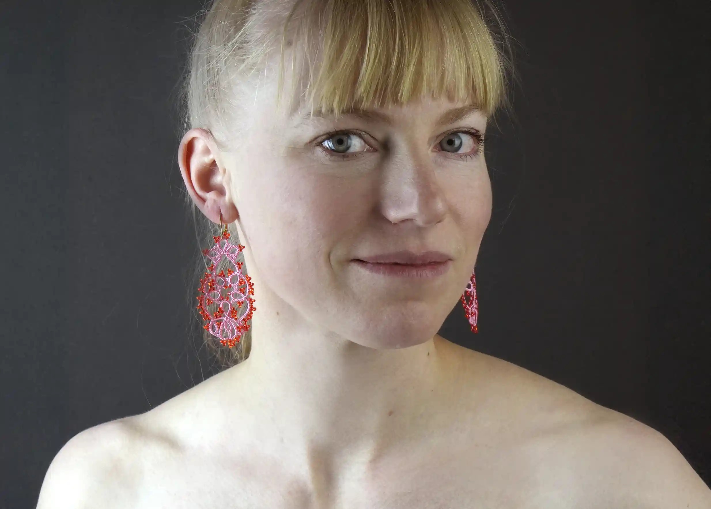 Woman wearing handmade lace jewellery, TREE model, rose red colour