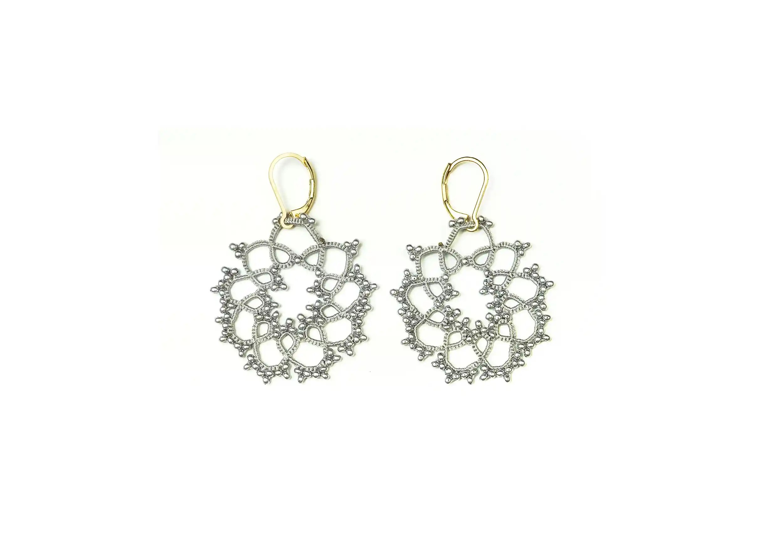 Boucles d'oreilles réalisées en fil et perles, au motif géométrique, coloris gris argent, photo prise sur fond blanc