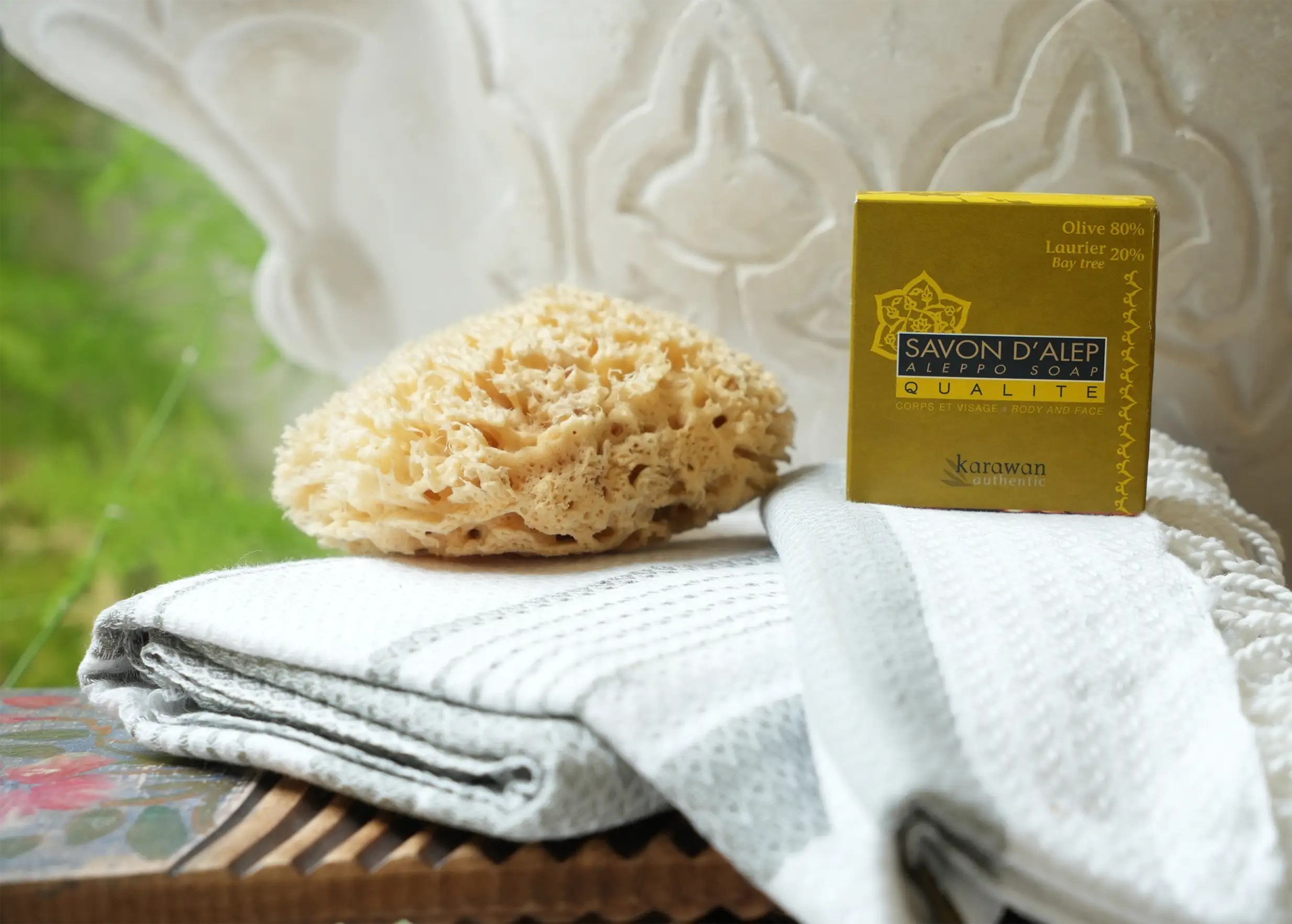 Box containing a 100g medium-sized Aleppo soap bar, made with 20% laurel oil, natural sponge and fouta