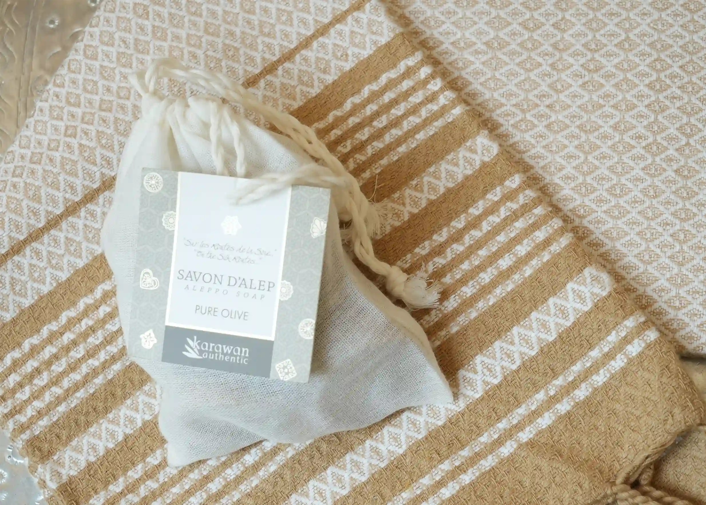Gift bag contaning authentic Aleppo soaps, seen on an organic cotton fouta