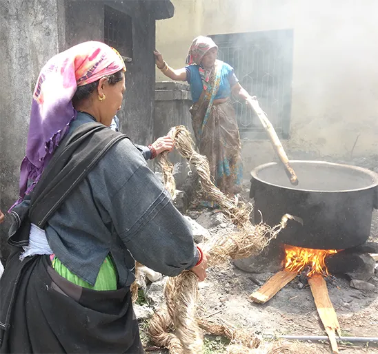 Two people carrying baskets of konjac plant fibres