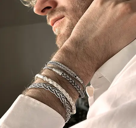 Homme portant au poignet un ensemble de bracelets en argent de la collection de bijoux Kokaz