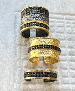 Ensemble d'anneaux et bagues en laiton à l'effet doré, ornés d'une bande de zirconium noir, collection Nuit des Temps