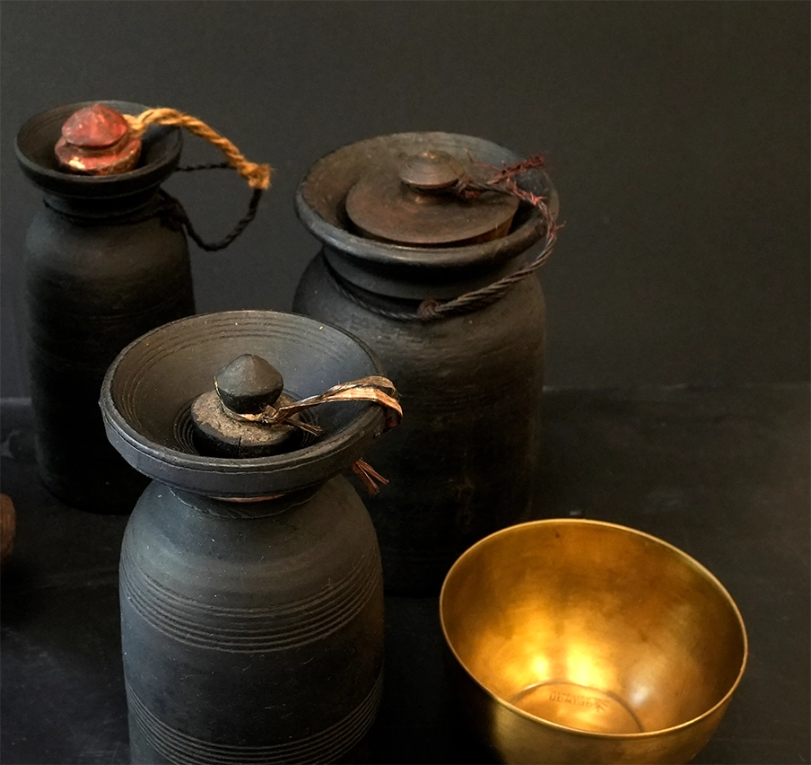 Ensemble de pots en bois, ainsi qu'un bol en laiton, le tout sur fond noir