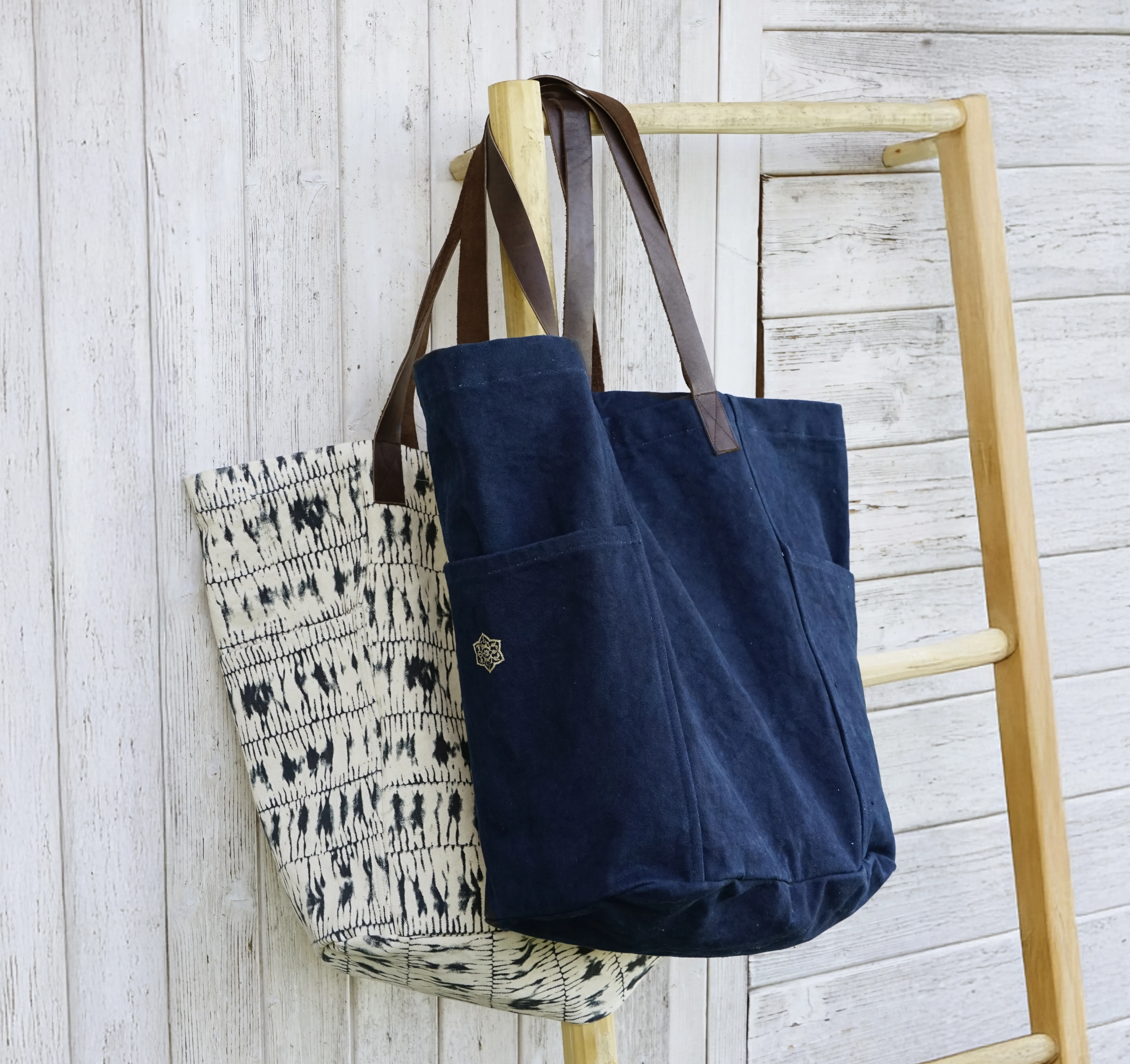 Deux sacs de la marque Karawan authentic sur un portant en bois